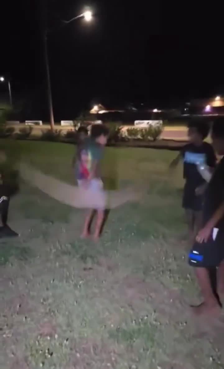 Australian Aboriginal children use dead python as a skipping rope in Woorabinda, Queensland