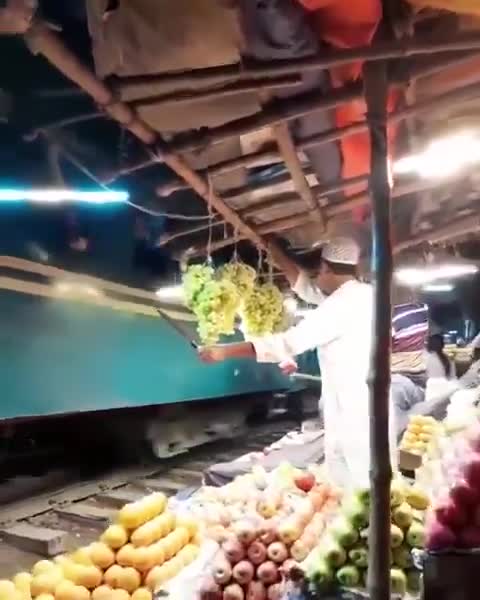 Fruit vendor protecting his grapes from train passengers in Bangladesh