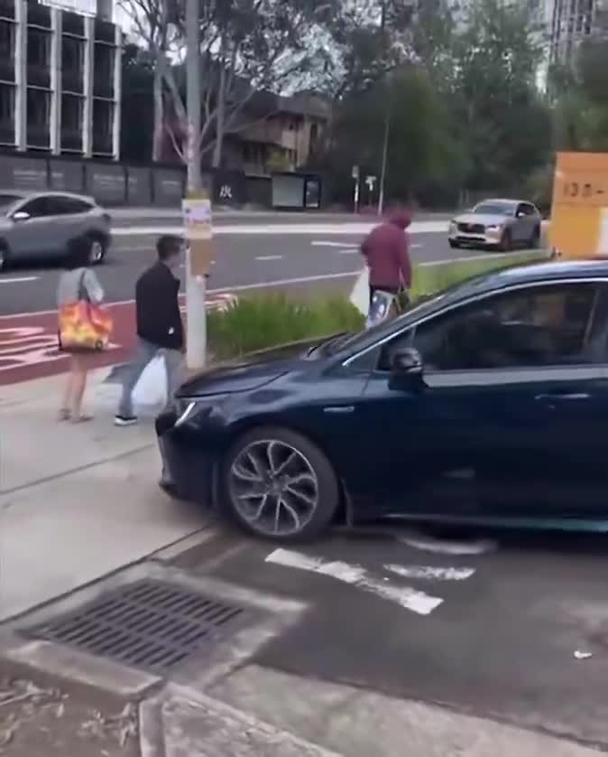 A man kicking political signs outside a pre-polling booth in Macquarie Park, Sydney