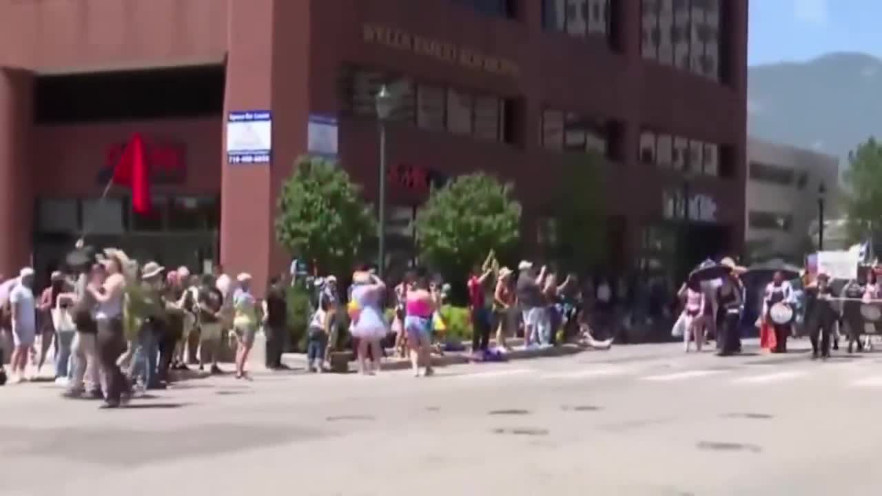 A satanic organization walked in the Pikes Peak Pride Parade as an announcer yells, \