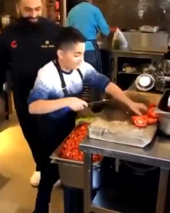 Chef father beams with pride as his son shows off his chopping skills