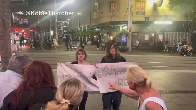 Two protesters stood outside Pauline Hanson's movie screening tonight in Sydney.  They held signs that read 